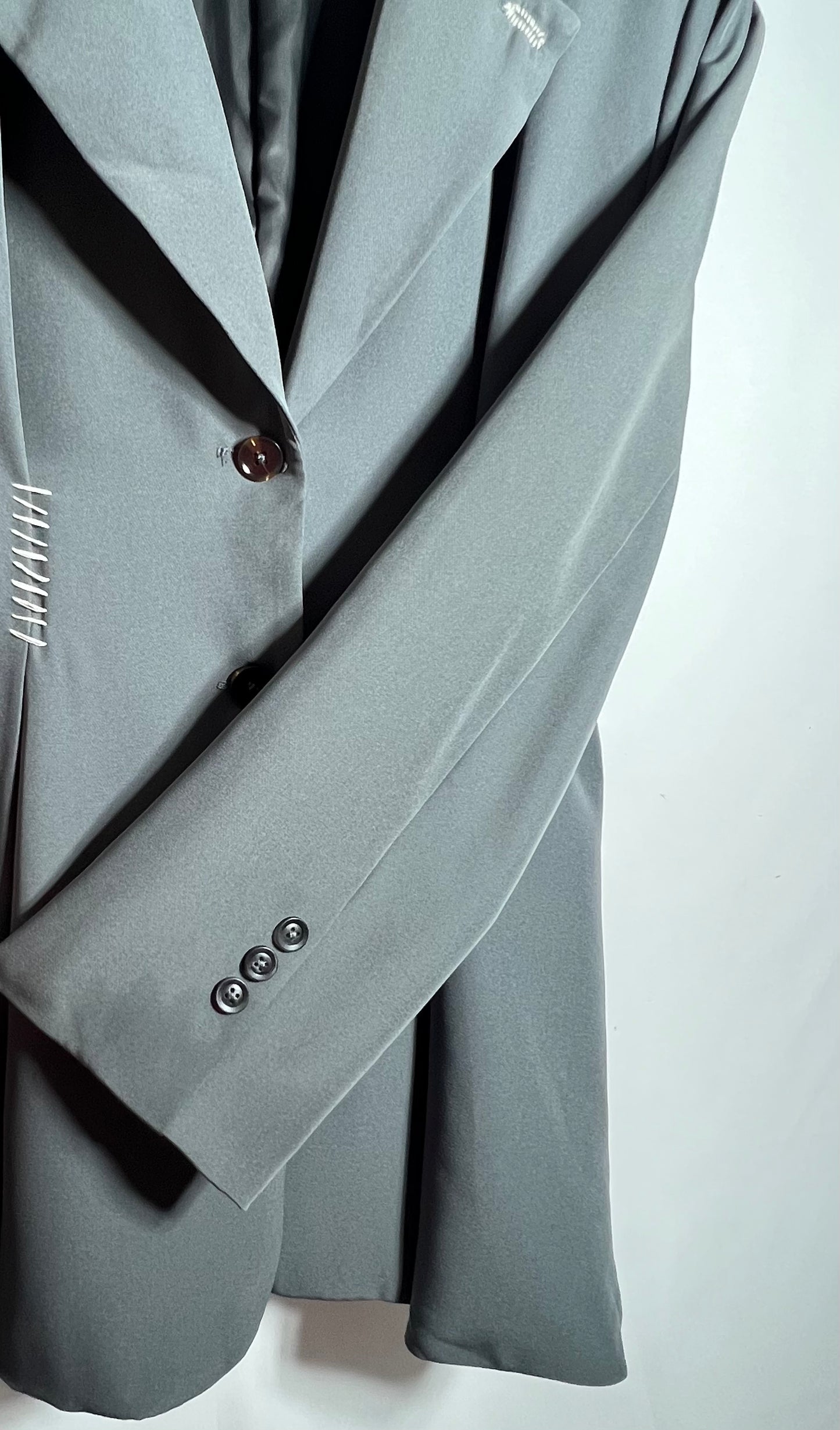 Gabardina con hombreras y detalle en blanco.