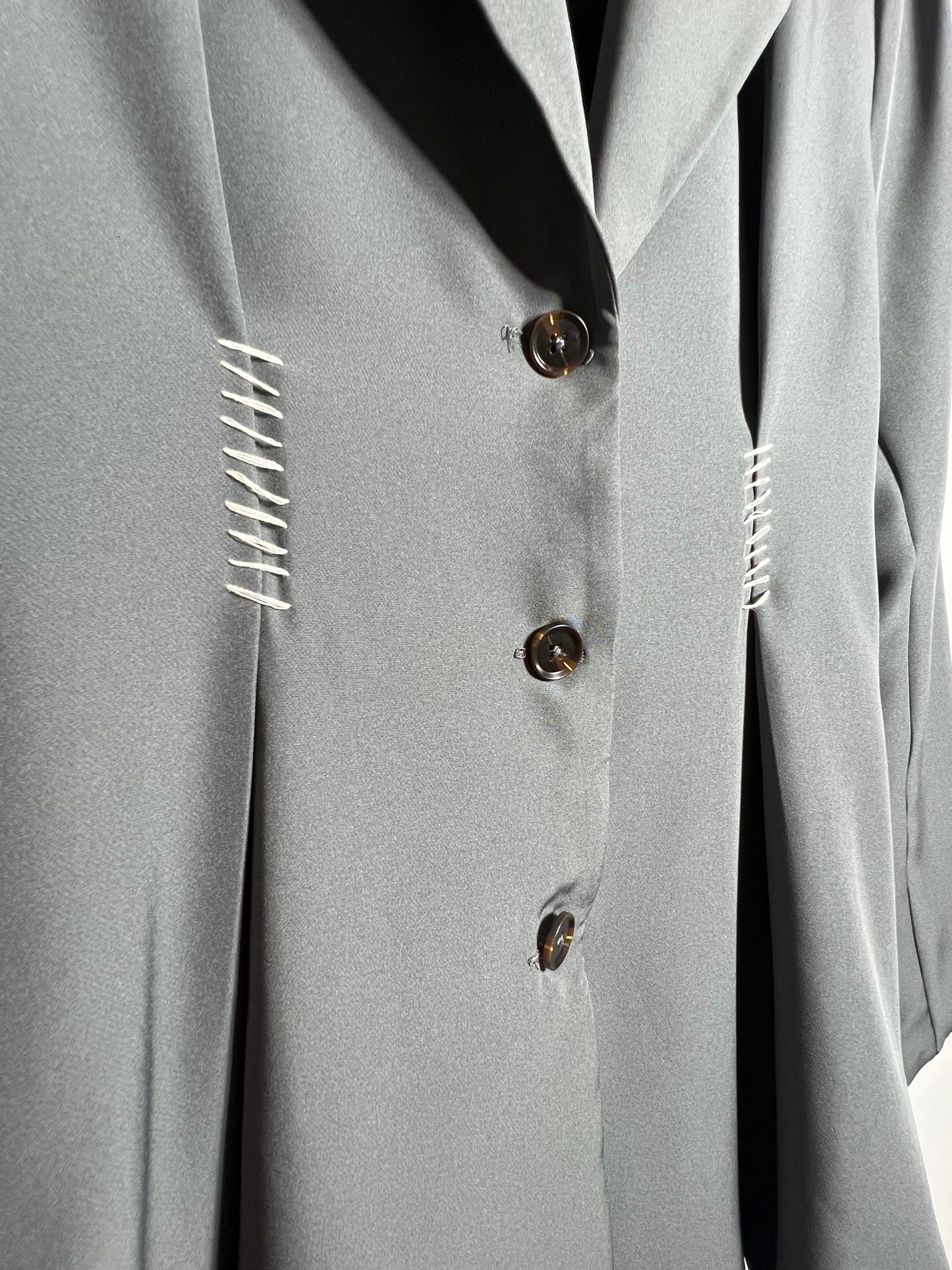 Gabardina con hombreras y detalle en blanco.