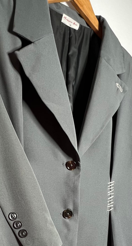 Gabardina con hombreras y detalle en blanco.